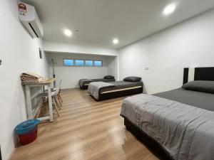 a bedroom with two beds and a desk in it at K SUITES HOTEL in Chabang Tiga