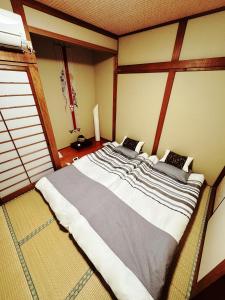 ein großes Bett in der Ecke eines Zimmers in der Unterkunft 山雲居 in Kyoto