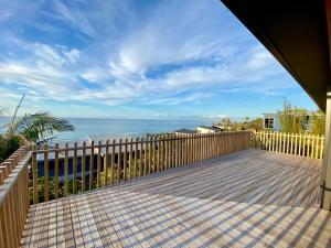 a wooden deck with a view of the ocean at Ahipara Beach Pad in Ahipara