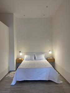um quarto com uma grande cama branca e 2 candeeiros em Martita House em Clorinda