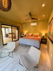 a bedroom with a bed and two chairs at Quinta Viajero in Zipolite