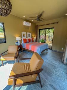 a bedroom with a bed and a couch and a chair at Quinta Viajero in Zipolite