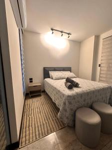 um pequeno quarto com uma cama e 2 cadeiras em Departamento de lujo en zona exclusiva em Santa Cruz de la Sierra