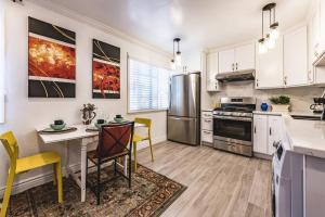 a kitchen with white cabinets and a table and chairs at Stanford Traveler's love & Cozy Bay trail house in East Palo Alto