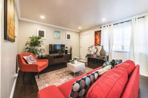 a living room with a red couch and a tv at Stanford Traveler's love & Cozy Bay trail house in East Palo Alto
