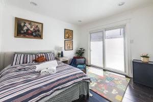 ein Schlafzimmer mit einem Bett und einem großen Fenster in der Unterkunft Stanford Traveler's love & Cozy Bay trail house in East Palo Alto