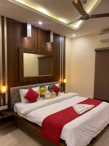a bedroom with a large bed with red pillows at Hotel Sukoon Bharatgarh in Rūpnagar
