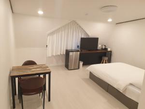 a bedroom with a bed and a table and a desk at Seorak HOT Spring Mammoth Resotel in Sokcho