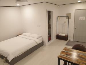 a bedroom with a bed and a table and a shower at Seorak HOT Spring Mammoth Resotel in Sokcho