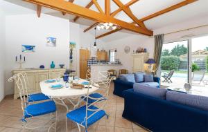a living room with a table and blue chairs at Le Domaine De Vertmarines in Saint-Jean-de-Monts