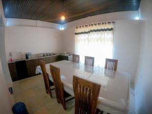 a dining room with a white table and chairs at Knuckles Range Bunglow in Kandy