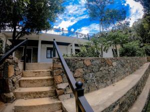 una casa con escaleras y una pared de piedra en Knuckles Range Bunglow en Kandy