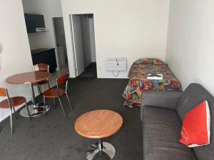 Habitación con sofá, mesa y cama en Ascot Motor Lodge en Wellington
