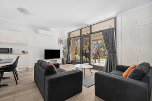 un soggiorno con due divani e una cucina di Riversands Rest Accommodation Paringa - Tea Tree Cottage a Renmark