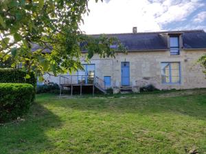 una antigua casa de piedra con puertas azules y un patio en Maison Coussay-les-Bois, 5 pièces, 10 personnes - FR-1-541-100, en Coussay-les-Bois
