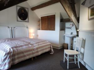 1 dormitorio con 1 cama y 1 silla en Maison Coussay-les-Bois, 5 pièces, 10 personnes - FR-1-541-100, en Coussay-les-Bois