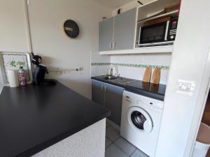 uma cozinha com uma máquina de lavar roupa e um micro-ondas em Appartement Saint-Cyprien, 2 pièces, 4 personnes - FR-1-776-22 em Saint-Cyprien