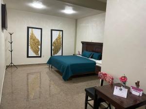 - une chambre avec un lit et trois photos sur le mur dans l'établissement HOTEL OTOMI, à Otumba de Gómez Farías