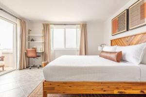 Un dormitorio con una gran cama blanca y una ventana en Relax and Unwind Luxe Home Blocks from Beach, en Hermosa Beach