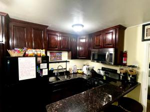 a kitchen with wooden cabinets and a black counter top at 3Mins.Airport/Fort Bliss-Pet Friendly-Washer/Dryer in El Paso