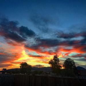 una puesta de sol con un cielo nublado con árboles y una valla en 3Mins.Airport/Fort Bliss-Pet Friendly-Washer/Dryer, en El Paso