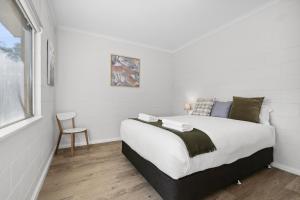 a bedroom with a bed and a chair at Riversands Rest Accommodation Paringa - Willow Cottage in Renmark