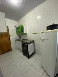 uma pequena cozinha com um fogão e um frigorífico em Casa na praia do balneário São Pedro em São Pedro da Aldeia
