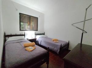 1 dormitorio con 2 camas y ventana en Casa Suyay en Londres