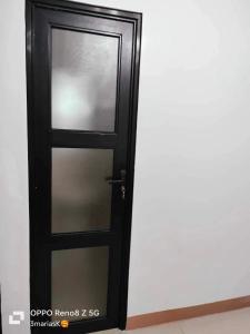 a black door with a glass window in a room at 3K’s Transient house in Bagac in Malawin