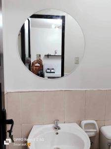 een spiegel in een badkamer met een wastafel en een toilet bij 3K’s Transient house in Bagac in Malawin