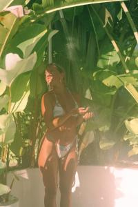 a woman in a bikini standing in front of a plant at Sky House Santa Teresa - Adults only in Santa Teresa Beach