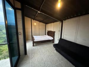 mały pokój z łóżkiem i oknem w obiekcie Glamping Moterio w mieście Santa Rosa de Cabal