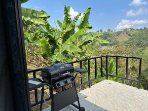 a grill on a balcony with a view of bananas at Glamping Moterio in Santa Rosa de Cabal