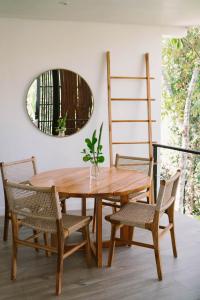 uma mesa de madeira e cadeiras num quarto com um espelho em Sky House Santa Teresa - Adults only em Santa Teresa