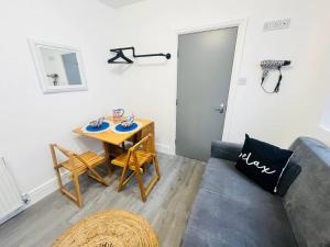 Centrally Located Stylish Studio Apt في ليفربول: غرفة معيشة مع طاولة وأريكة
