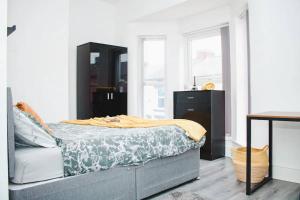 a bedroom with a bed with a yellow blanket on it at Elegant 4Bed House near the City Centre in Liverpool