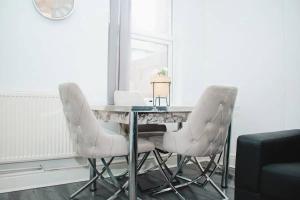 mesa de comedor con sillas blancas y espejo en Elegant 4Bed House near the City Centre en Liverpool