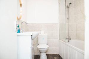 a bathroom with a toilet and a sink and a tub at Elegant 4Bed House near the City Centre in Liverpool