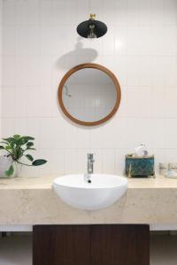 W łazience znajduje się biała umywalka i lustro. w obiekcie Luxe Paradise residence 22 Nam Ngu street w mieście Hanoi