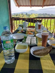 a table with plates of food and a bottle of water at Ridge Boundary View in Dambulla