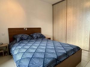 Schlafzimmer mit einem Bett mit einer blauen und weißen Bettdecke in der Unterkunft Appartement Argelès-sur-Mer, 2 pièces, 4 personnes - FR-1-225-803 in Argelès-sur-Mer
