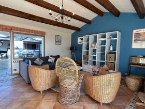 ein Wohnzimmer mit Korbstühlen und einem Sofa in der Unterkunft Maison confortable face à la mer, 7 couchages, terrasse, jardin, wifi, parking, animaux acceptés - FR-1-224B-211 in La Guérinière