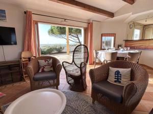 ein Wohnzimmer mit Korbstühlen und einem Tisch mit Aussicht in der Unterkunft Maison confortable face à la mer, 7 couchages, terrasse, jardin, wifi, parking, animaux acceptés - FR-1-224B-211 in La Guérinière