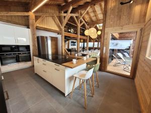 a kitchen with wooden ceilings and a table and chairs at Chalet Les Gets, 8 pièces, 14 personnes - FR-1-598-161 in Les Gets