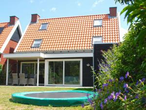 uma casa com um trampolim no quintal em Beautiful holiday home in Colijnsplaat with garden em Colijnsplaat