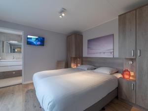 um quarto com uma cama grande e uma casa de banho em Beautiful holiday home in Colijnsplaat with garden em Colijnsplaat