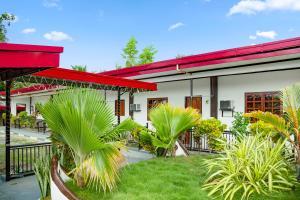 a house with a red roof and some palm trees at Hiddennest Guest house in Alcantara