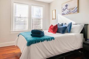 um quarto com uma cama com almofadas azuis e vermelhas em Charming 4 Bedroom House!1 Mile from Capitol Hill! em Washington