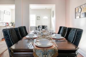 Charming 4 Bedroom House!1 Mile from Capitol Hill! في واشنطن: غرفة طعام مع طاولة مع أكواب وكراسي