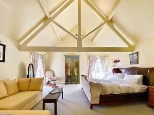 Oaklands Farm - Cottage 5 في Broughton: غرفة نوم بسرير كبير وأريكة